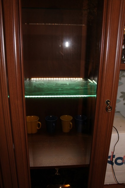 A háttérvilágítás üveg polcok a nappali falán segítségével LED szalag