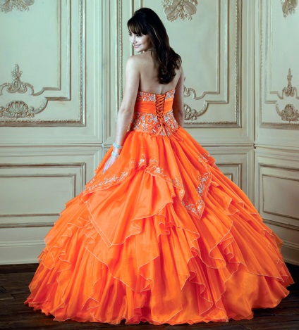 A lány egy esküvői narancssárga ruhában, smink alatt a narancssárga ruha