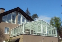 Az üvegház a tetőn egy garázs és egy magánházban, ablakok és videó, magas épületek, fotó fürdő és infomációval