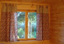 A függöny az ablakon a kis faházban, fotó függöny fürdő kialakítás keskeny falu