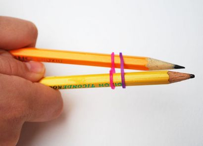 Make-Regenbogen-Loom-Armbänder unter Verwendung von zwei Bleistifte