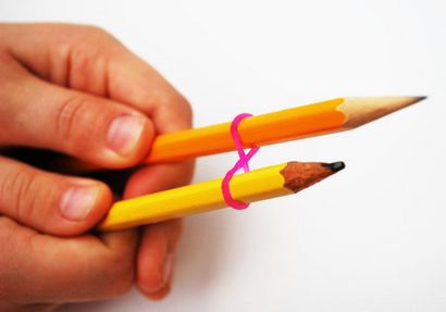 Make-Regenbogen-Loom-Armbänder unter Verwendung von zwei Bleistifte