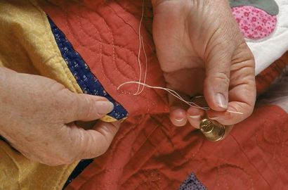 Utilisez le noeud d'un Quilter pour sécuriser Stitches quilter main