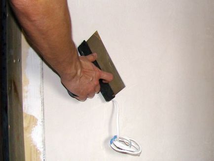 Önterülő gipsz falak egy spatulával kezét fotó és videó használati