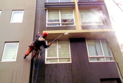 Измиване на прозорци и фасади на сгради с ръцете си като алпинистите работят