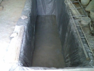 Инспекция яма в гаража с ръце като копаят и правят тухли от близо, изчисляването