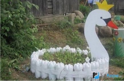 Палма и лебеди в езерото от пластмасови бутилки