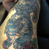 Oroszlán tetoválás egy Buddha vagy egy kutya fu