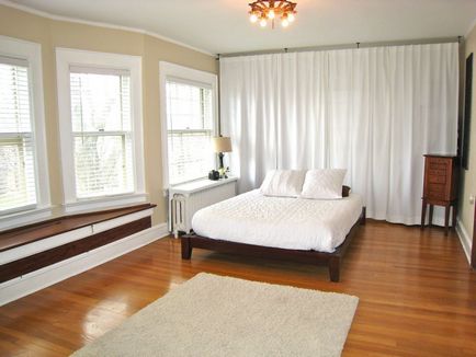 Podeaua din dormitor este umplută cu plută din lemn în interior, designul unui strat de lumină și întuneric alb