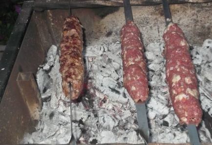 Lulia-kebab din carne de oaie pe un grătar și pe o tigaie