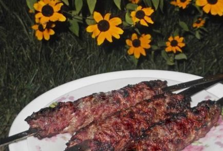 Lulia-kebab din carne de oaie pe o grătar și pe o tigaie