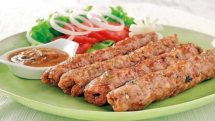 Lulia-kebab din carne de oaie pe un grătar și pe o tigaie