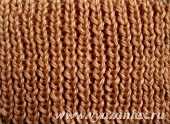 Un capac cu o bandă de cauciuc în engleză este realizat cu ace circulare de tricotat.