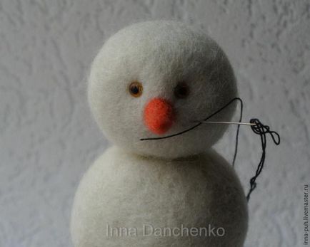 Omul de zăpadă sub un pom de Crăciun face o jucărie în tehnica de lână de îmbrăcăminte uscată - mâna dreaptă