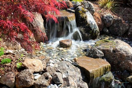 Cascada în curtea unor iazuri artificiale elegante în designul peisajului pe fotografie