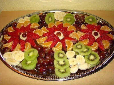 Szeletelő gyümölcs egy ünnepi asztalon látványos desszertek