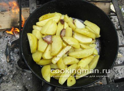 Sült burgonya szalonnával egy serpenyőben a tűzre - főzés férfiak (burgonya) Sült burgonya szalonnával egy serpenyőben a tűzre - főzés a férfiak
