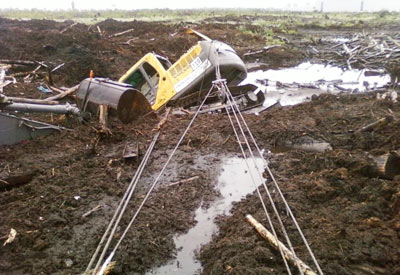 Az evakuálás elakadt gép, kotrógép, a traktor a mocsárból az iszap a gödörbe, honnan