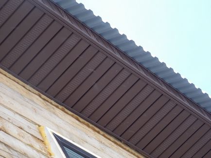 Placarea acoperișului cu tablă ondulată ca o coasere a cornișei acoperișului, finisarea șipcilor