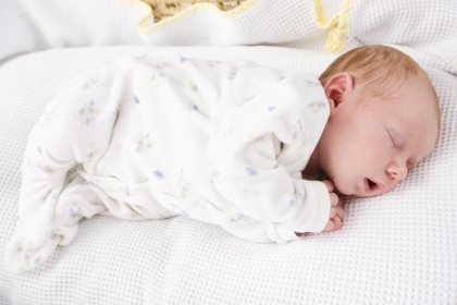 Jelent egy újszülött baba alszik a hasán oldalán vagy hátsó