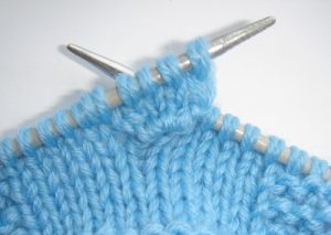 Modelul de tricotat al unui buton în conformitate cu schema, cu o descriere detaliată a fotografiilor