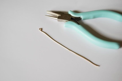 Nyaklánc-medál formájában egy tollat ​​egy szál