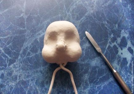 Sculpting a baba fejét a szerszámot, hogy vizsgálja felül az elkészült babák