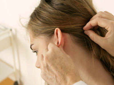 Прищ на мочці вуха, за вухами причини і лікування