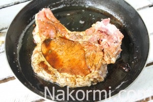 Friptura de carne de porc pe un os într-o rețetă de tigaie cu o fotografie