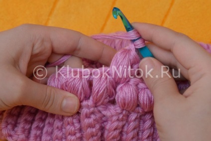 Un capac cu o schemă de panglică care descrie modul de realizare a acelor de tricotat