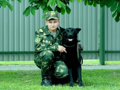 Людина і собака разом стоять на варті кордону, медіа-полісся