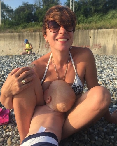Az előfizetők zokon Tutta Larsen szoptatás közvetlenül a tengerparton