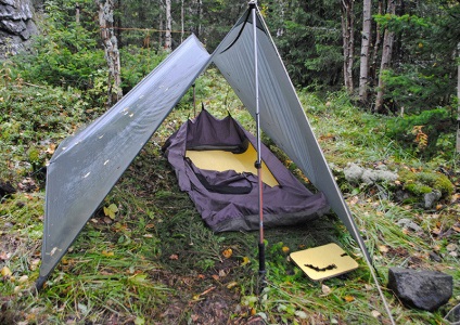 Cu mâinile lui o geantă de bivouac de casă, alpinistă