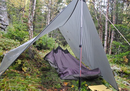 Cu mâinile lui o geantă de bivouac de casă, alpinistă