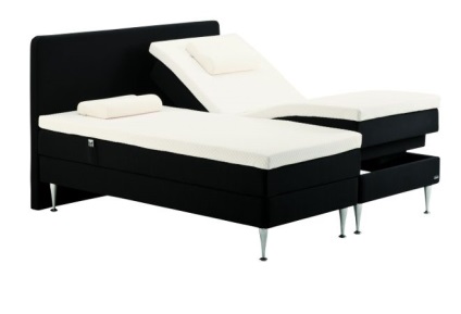 Az ágy fején egy modern, magas és alacsony fejlécű ágy található