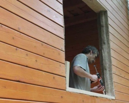 Az ablak nyílászárók és egy burkolat egy faházban