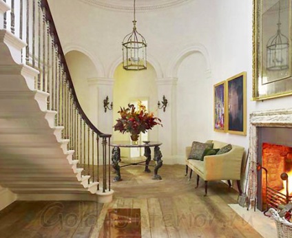 Interiorul halei în casă cu un stil de scară, mobilier și accesorii