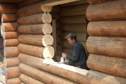 Învelirea unei ferestre de deschideri de ferestre într-o casă din lemn