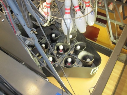 Partea opusă a dispozitivului pinsetter bowling, și aranja știfturile de colectare (colectare) Partea din spate a dispozitivului pinsetter bowling, care colectează și pune ace